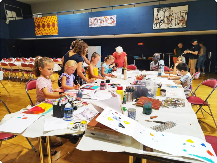 Phot pour la galerie du plasticien Pierre Quentel, dans cette photo on voit un groupe d'enfants lors d'un atelier animé par le peintre sur thème fête en Afrique, en collaboration avec l'association à Guiclan