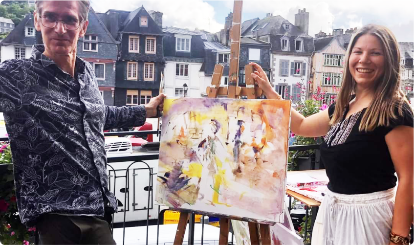 Photo pour la galerie du plasticien Pierre Quentel, dans cette photo on trouve Pierre et à coté de lui la danseuse Orsolya qui posent devant une des toiles faite en direct lors de la performance et derrière eux on voit le marché de samedi à Morlaix